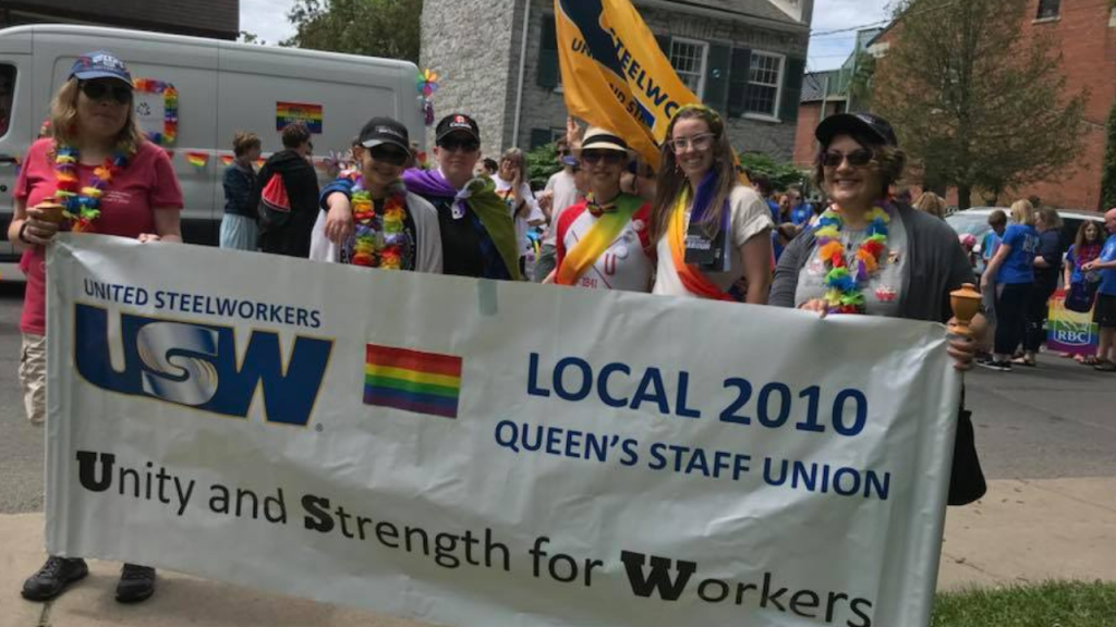 Steelworkers at a Kingston Pride Parade, holding a USW Local 2010 Pride Banner